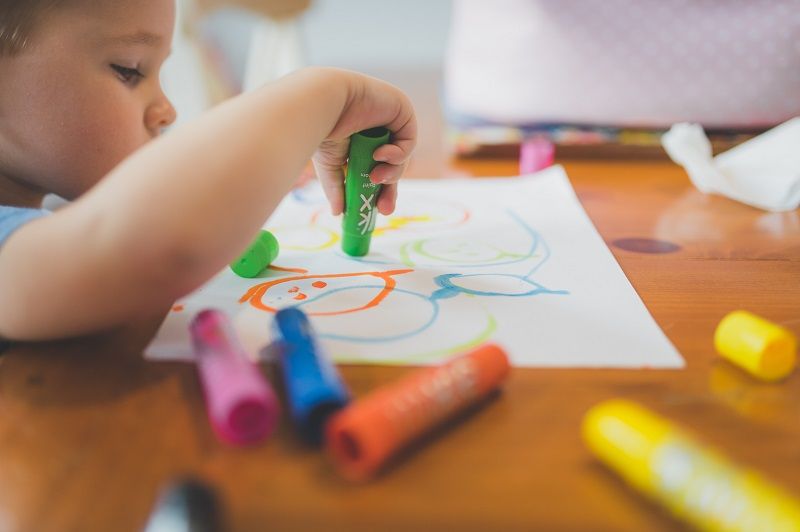 child drawing with crayons